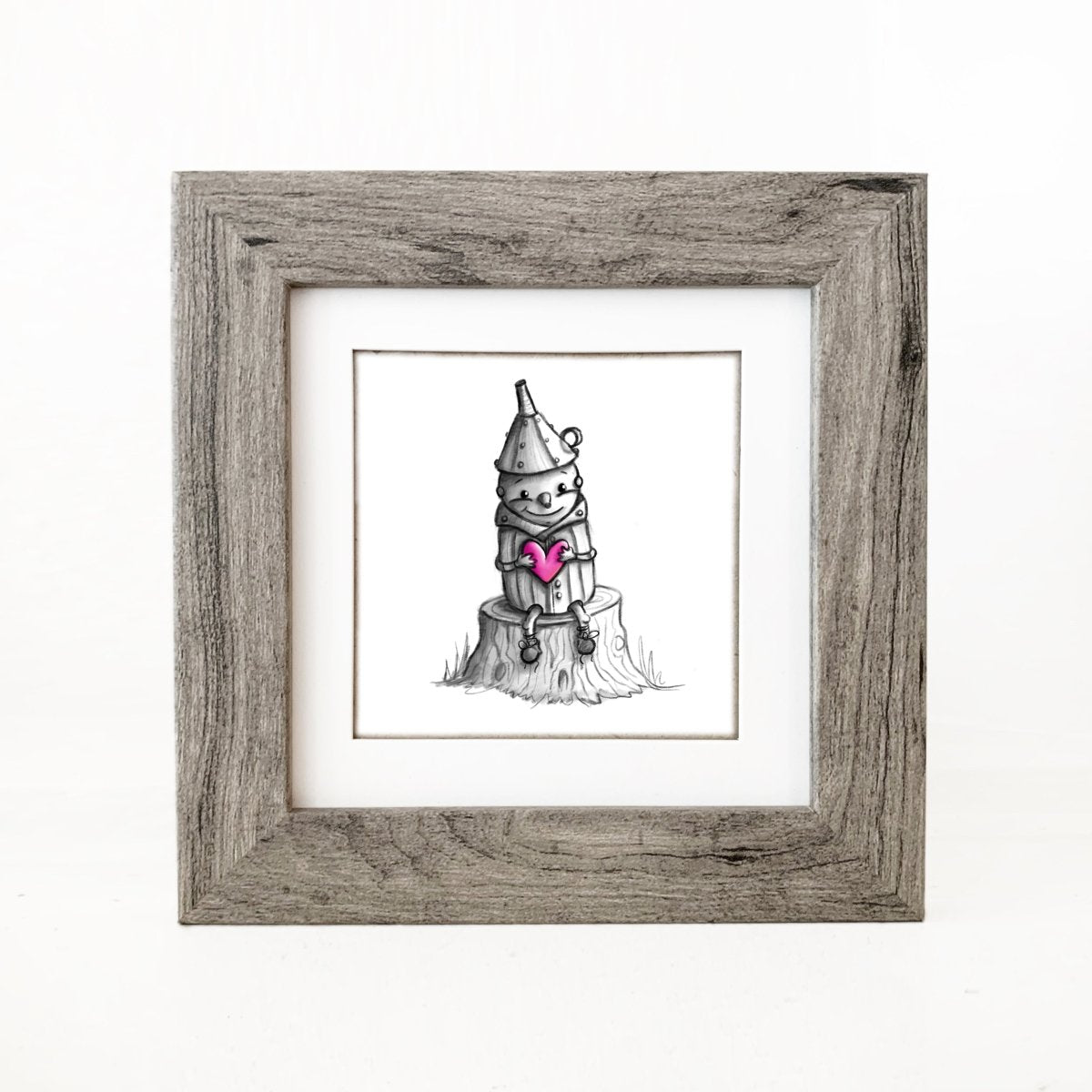 tin-man-holding-heart-sitting-on-stump-illustration-grey-frame